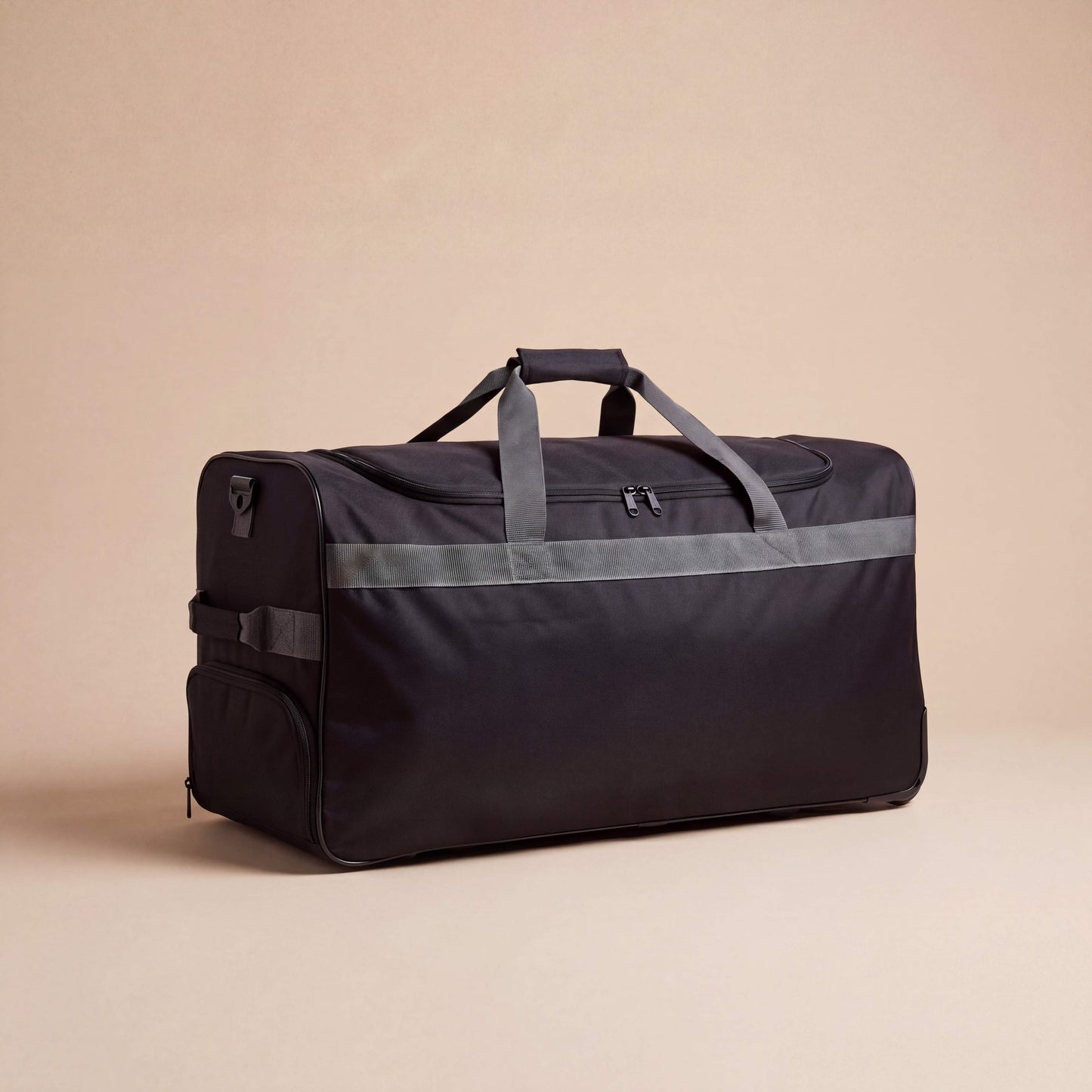Black duffel bag with reflective stripes on a beige background