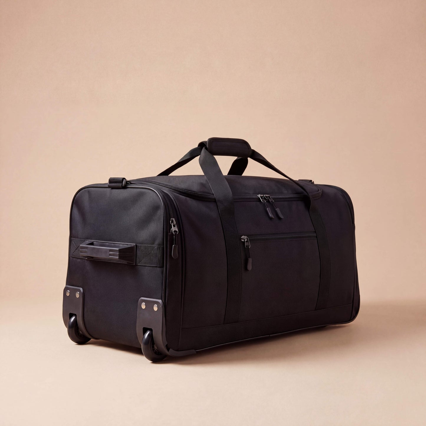 Black travel duffel bag on a beige background