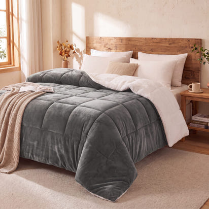 Gray teddy sherpa ultra warm doona on a bed in a cozy bedroom with wooden headboard and side tables.