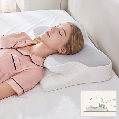 Woman lying on a white bed with a white pillow, wearing pink pajamas.
