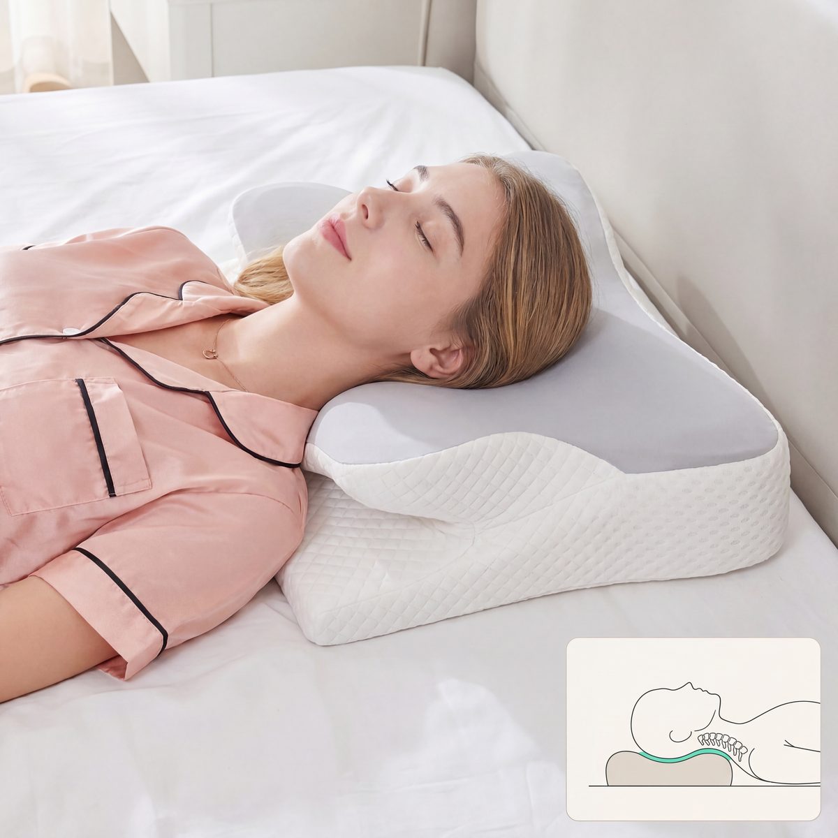 Woman lying on a white bed with a white pillow, wearing pink pajamas.