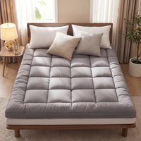 Gray mattress cover on a bed with pillows in a bedroom setting