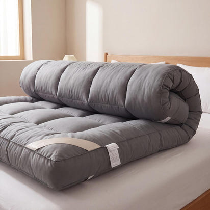 Gray mattress topper on a bed in a bedroom setting