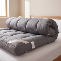 Gray mattress topper on a bed in a bedroom setting